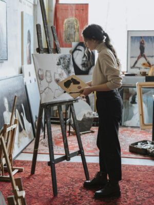 Female artist painting on canvas in a vibrant studio space, showcasing creative process.