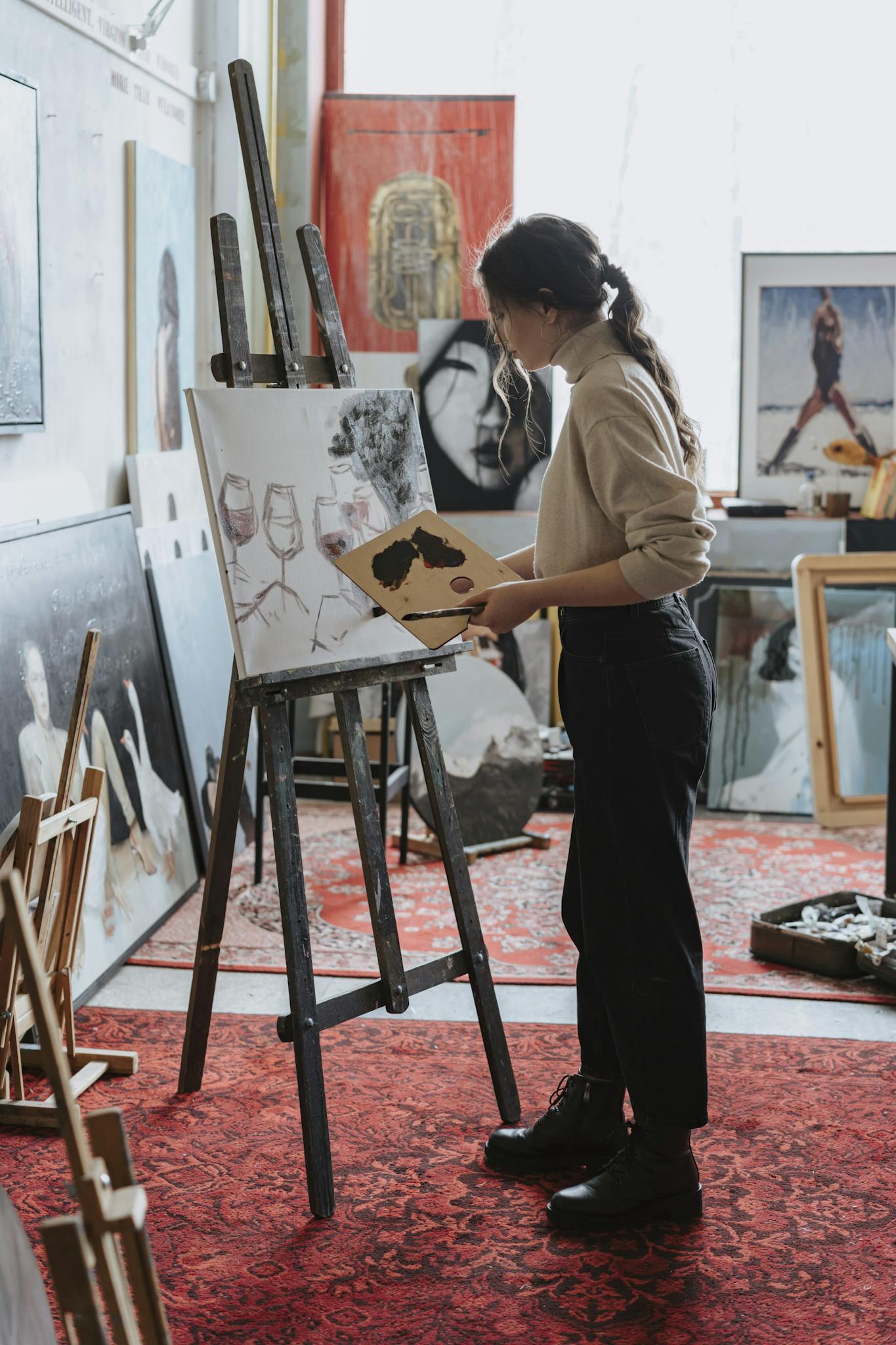 Female artist painting on canvas in a vibrant studio space, showcasing creative process.